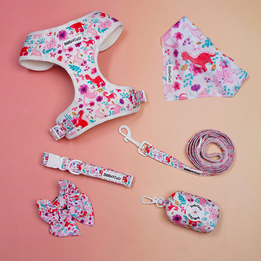 Dog harness, leash, bandana, and other accessories with floral pattern on a pink background