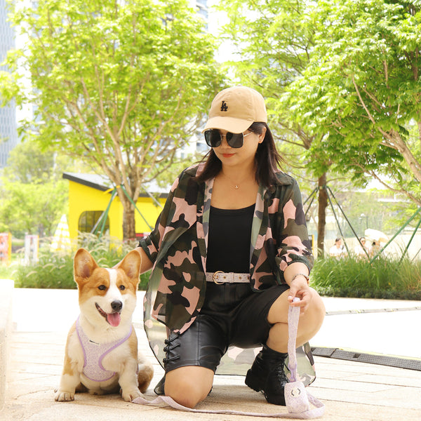 Dog mom outdoors with a Corgi wearing a small dog harness and leash