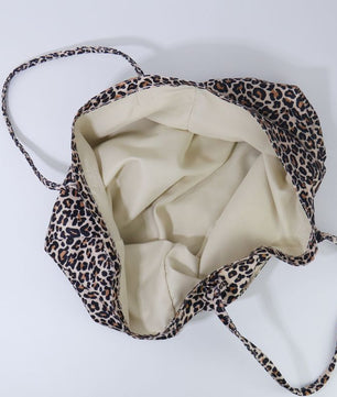 A leopard print shoulder bag with a cream-colored interior lining, shown from a top-down view on a light gray background.