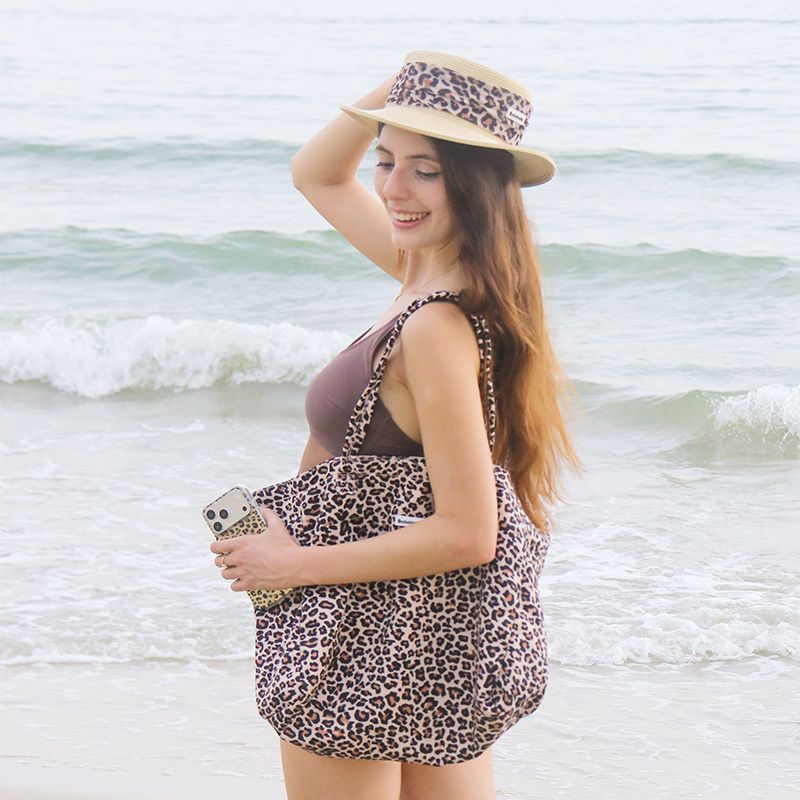 Leopard beach tote bag paired with matching dog accessories for stylish outdoor adventures with your dog.