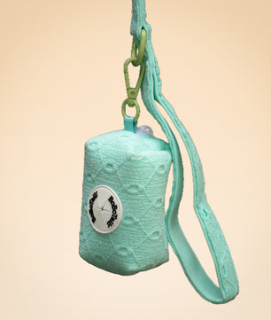 Turquoise textured pouch with a strap on a beige background