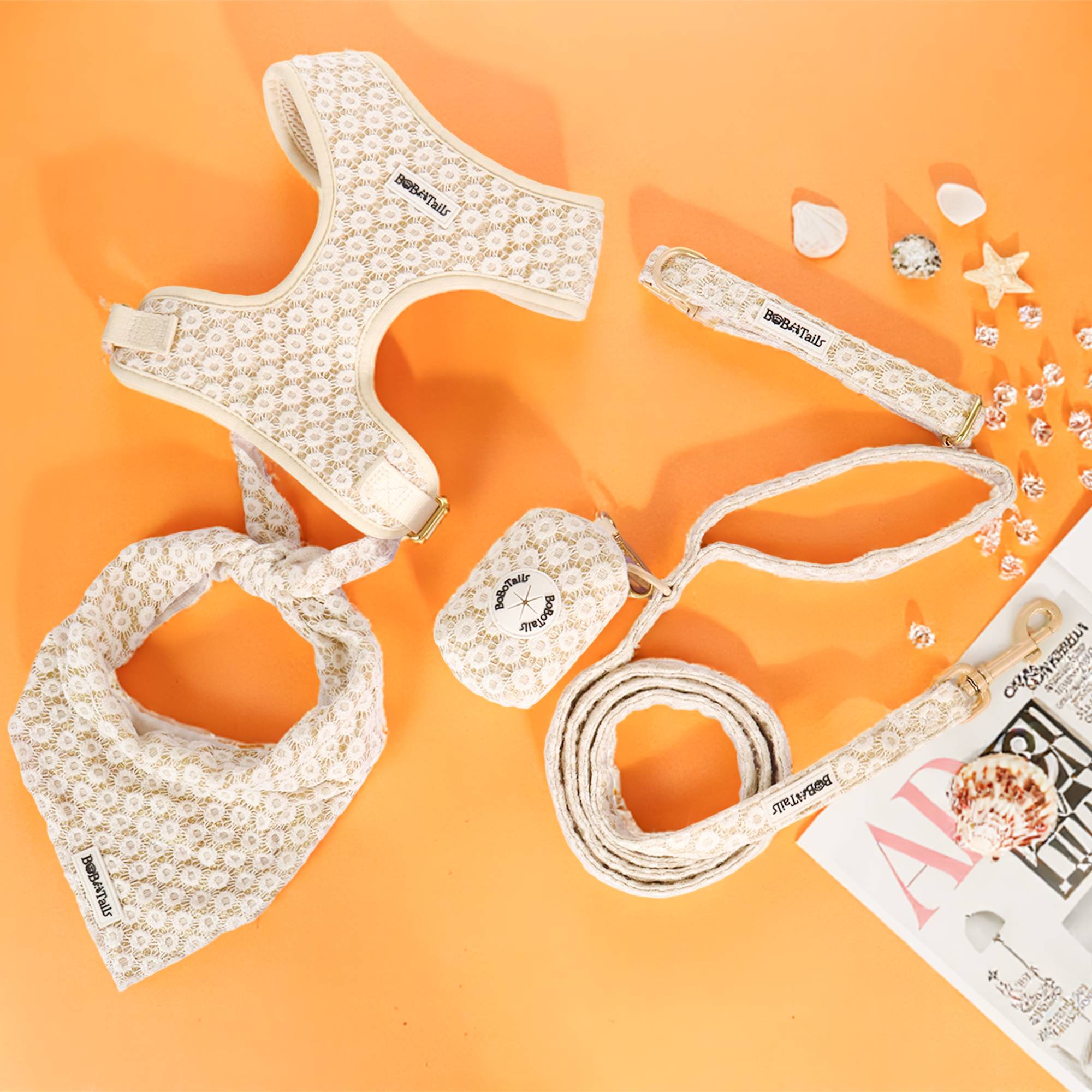 Dog accessories including a harness, leash, bandana, and small pouch on an orange background.
