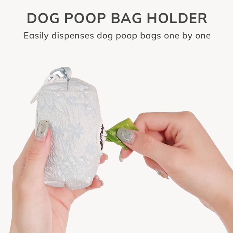 Dog poop bag holder with hands dispensing a bag of dog waste matching the leopard harness and owner accessories for daily dog walks